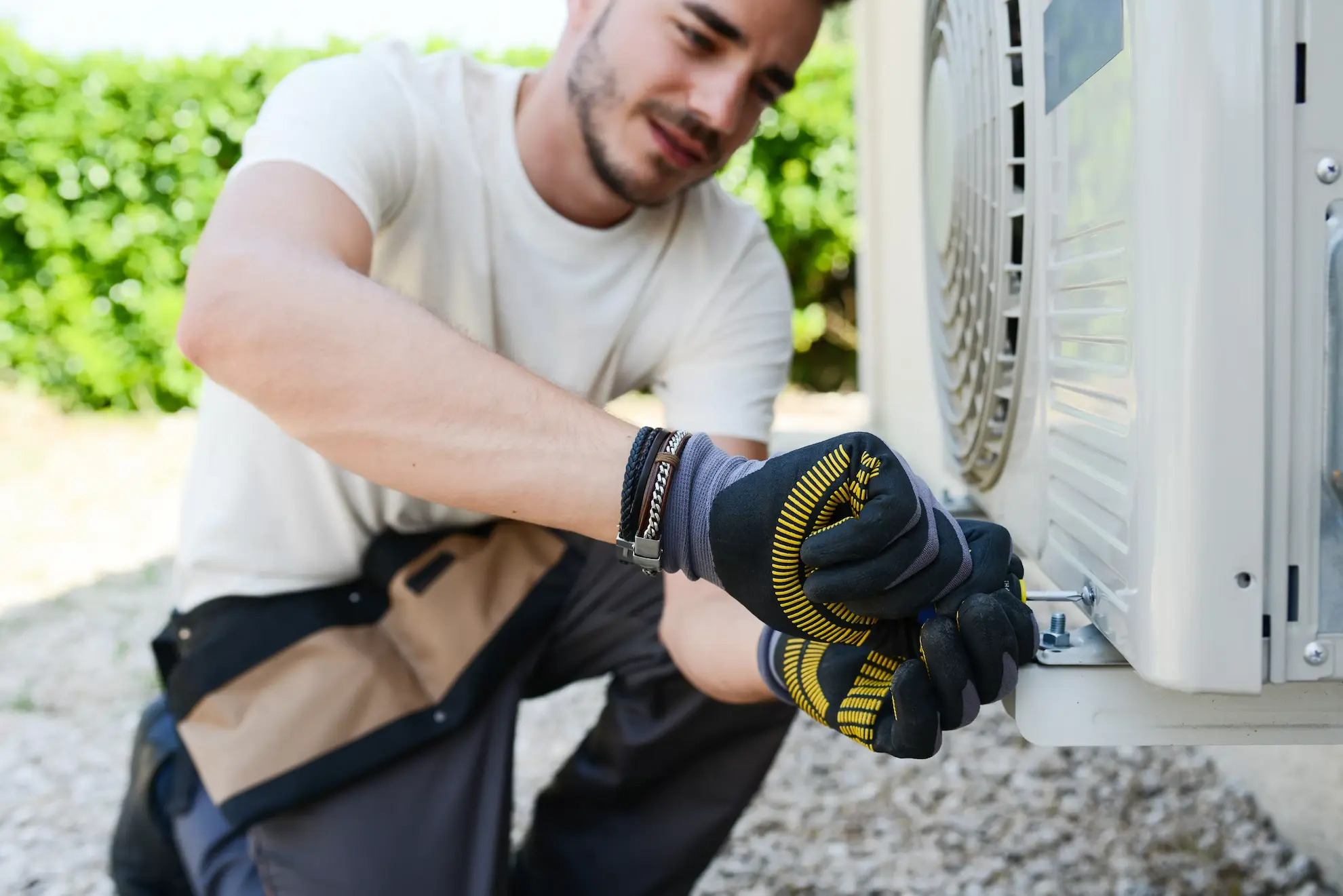 Technicus installeert een airconditioningsunit buiten voor een airco webwinkel.